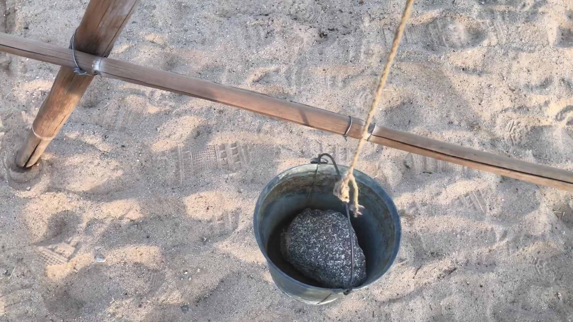 01 Calibrating A Frame Level With Rope Pail Rock And Wire Marker