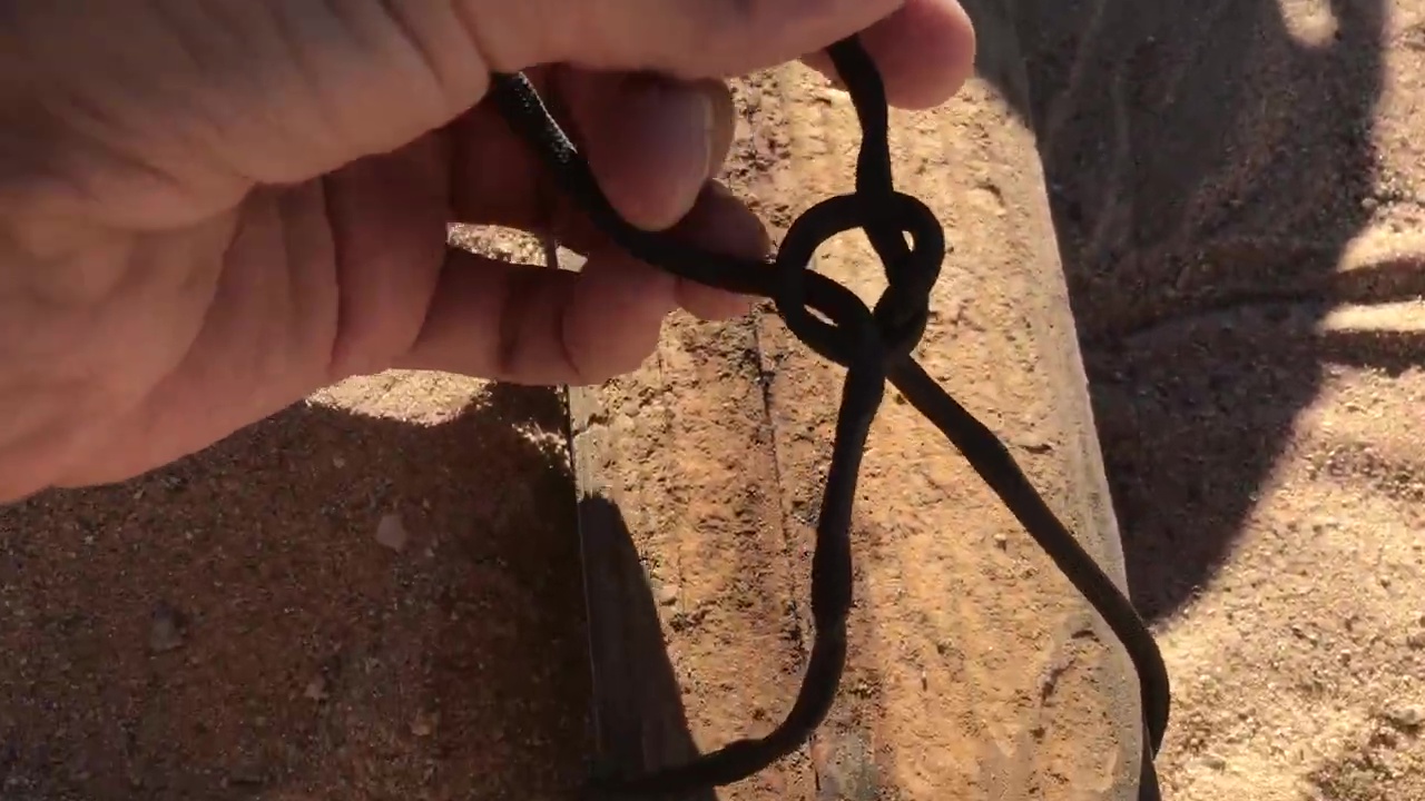 01 Tying Knot Around Piece Of Wood To Anchor Paracord Rope Underground 01