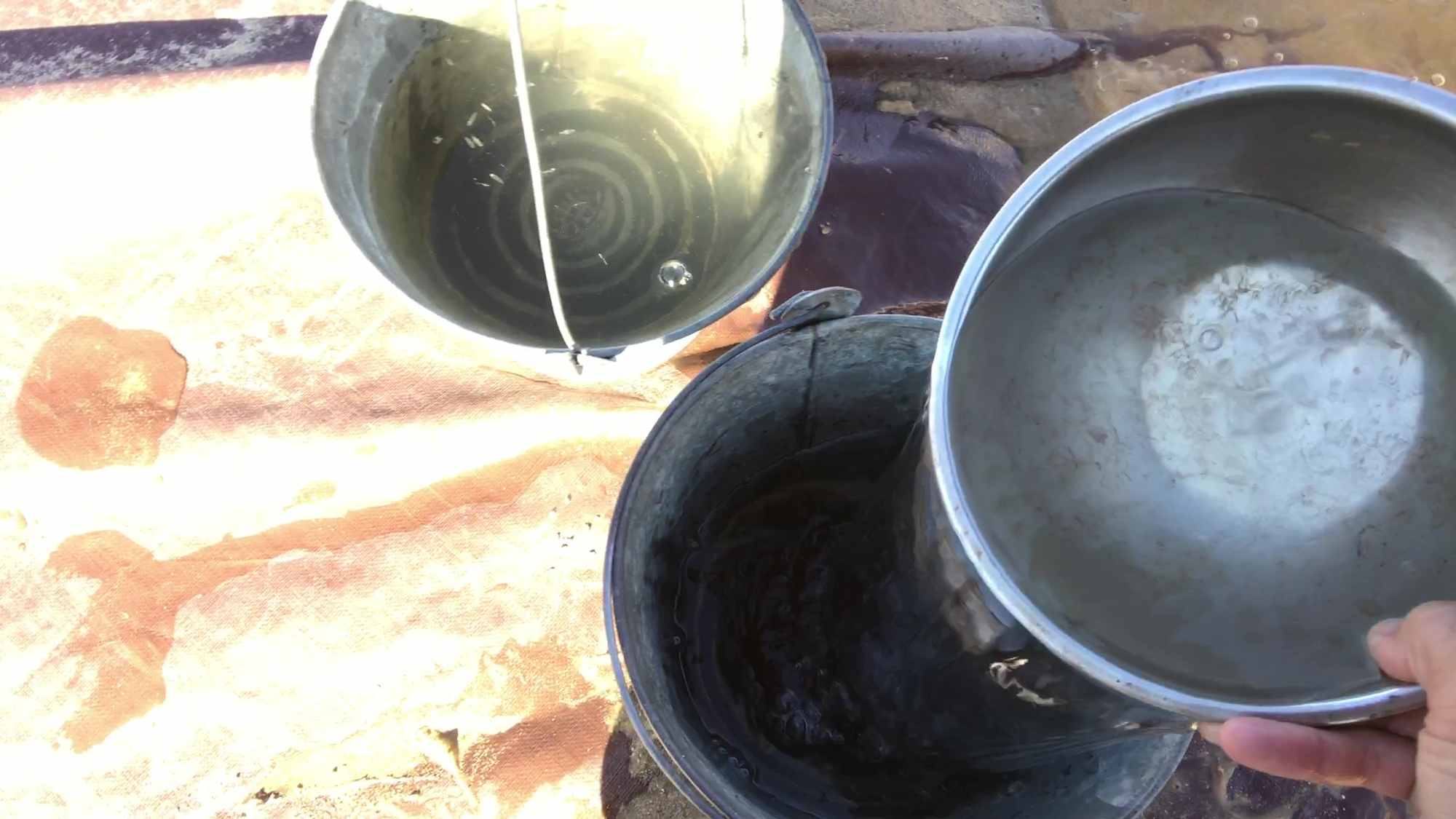 09 Pouring Metal Bowl of Rain Water Into Metal Pails