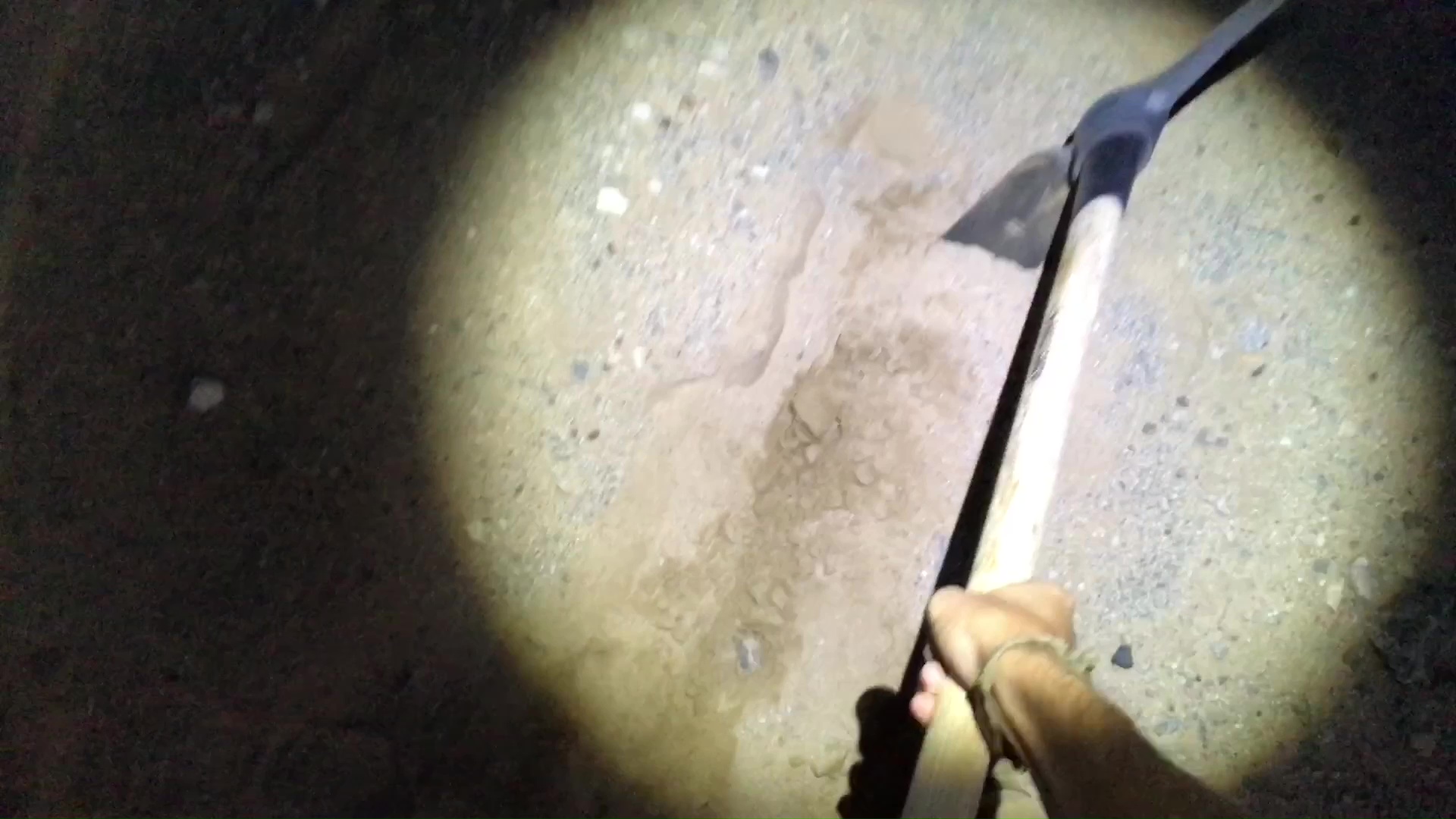 Clearing Sand Paths At Night With Pick Axe